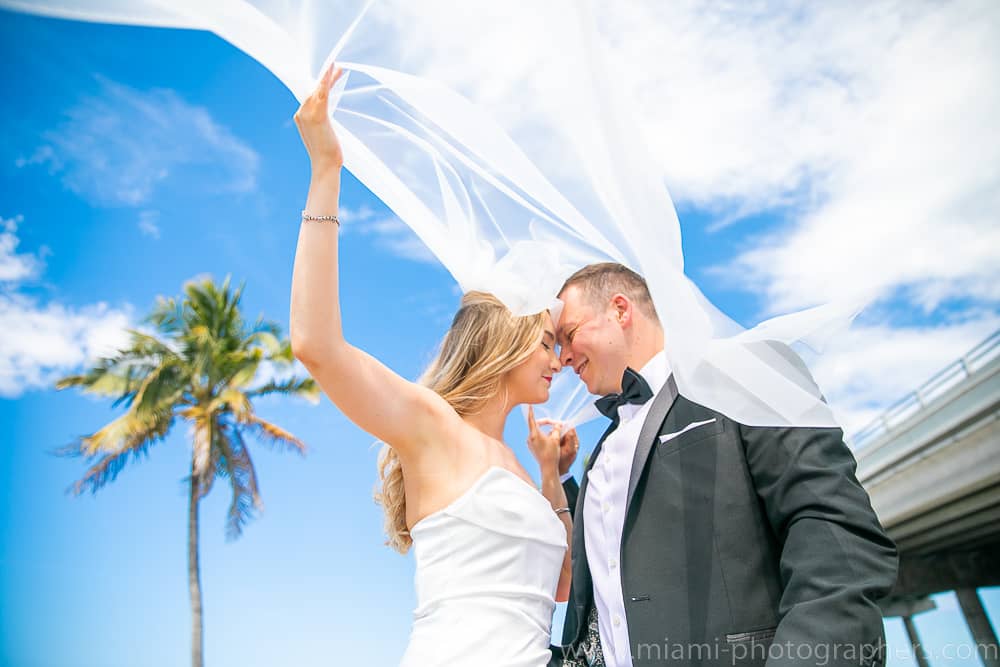 Bride and groom sharing a tender moment on a Miami beach during their chic elopement, with soft natural lighting and ocean views.