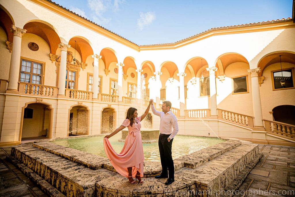 Engagement Photographer Miami 19 Newlyweds sharing a romantic moment under the grand arches of the Biltmore Hotel in Coral Gables, captured by a Miami wedding photographer