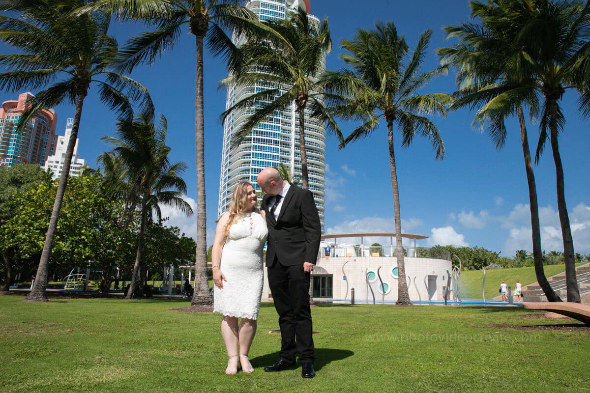 Bride and groom smiling together outside Miami City Hall during their romantic courthouse wedding in Miami Beach
