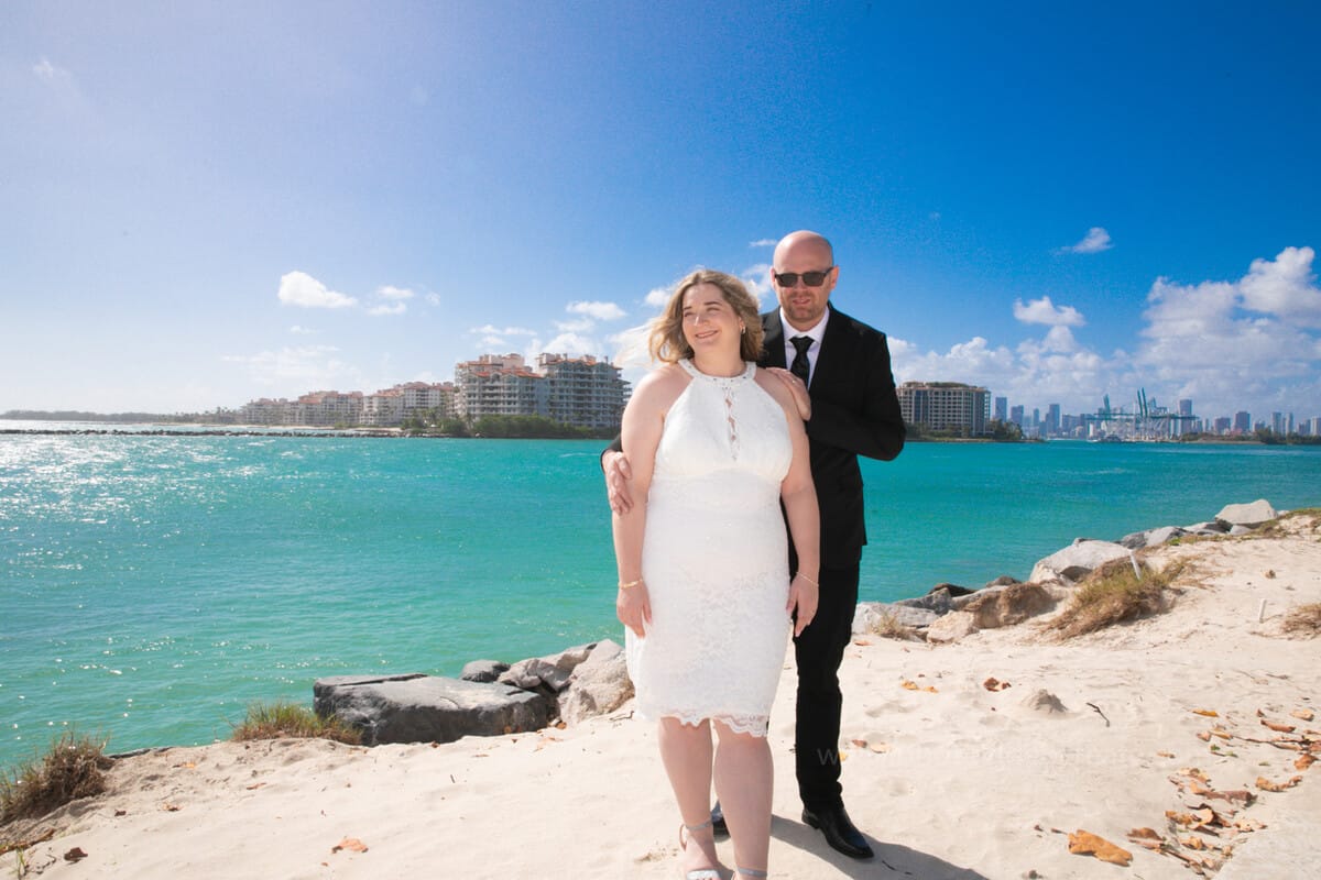 Bride and groom walking hand-in-hand outside Miami Beach City Hall during their wedding day