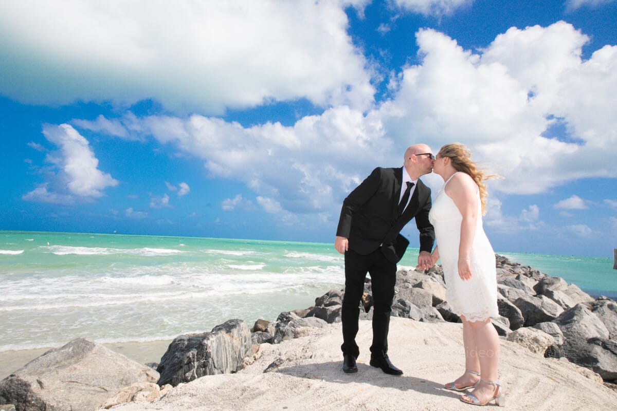 Couple sharing a joyful moment outside Miami City Hall during their wedding photoshoot in Miami Beach