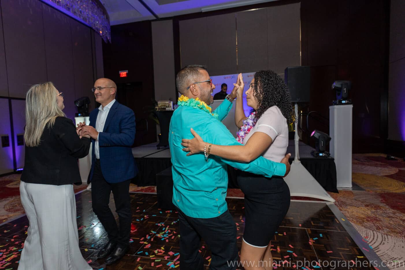 Newlywed couple smiling and walking hand-in-hand after their Jewish wedding ceremony in Miami.```
