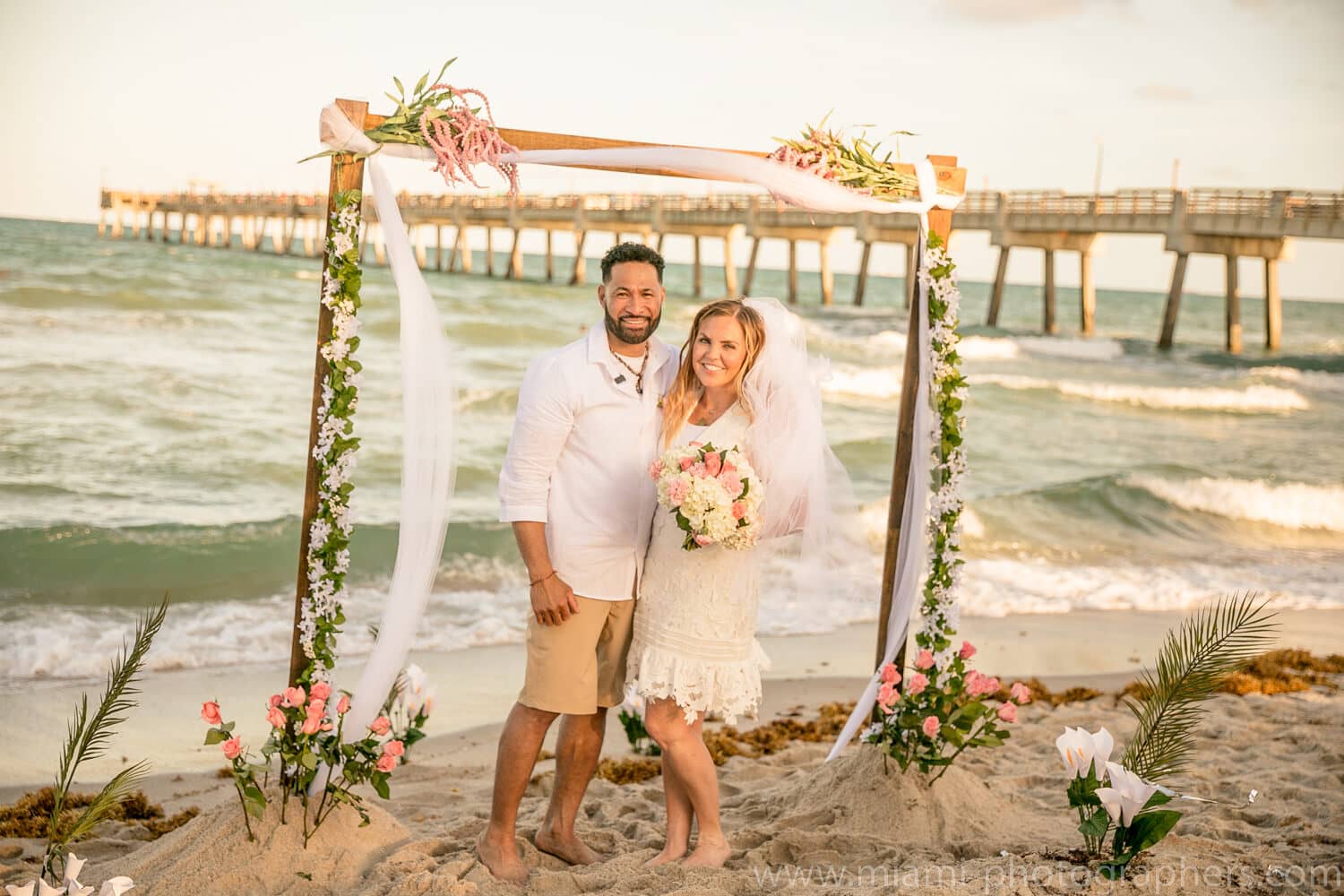 Bride and groom celebrating their beach wedding in Miami, photographed by a local professional wedding photographer near the shoreline