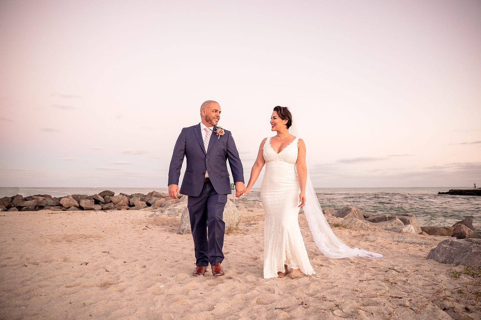 Couple posing for a romantic post-wedding photoshoot on Miami Beach with ocean backdrop.