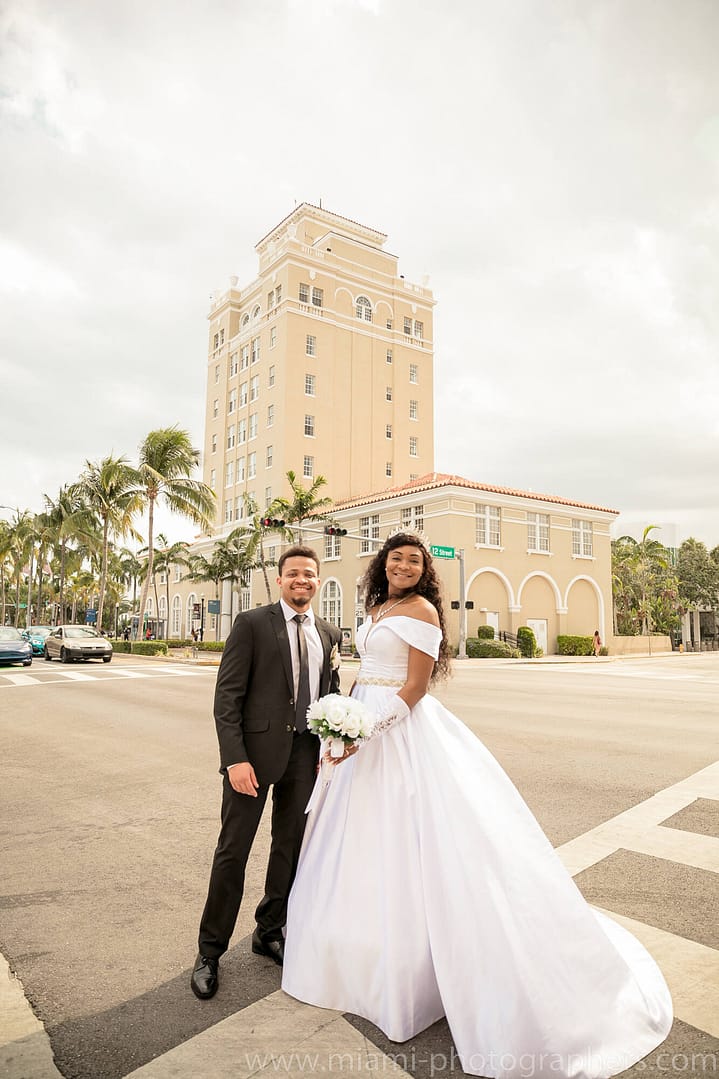 Happy bride and groom smiling together under the chuppah during a Jewish wedding ceremony in Miami.
