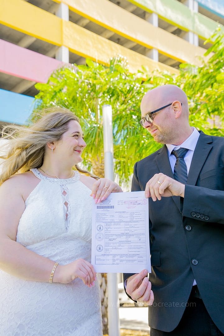 Newlywed couple holding hands and walking away from Miami Beach City Hall after their civil wedding ceremony