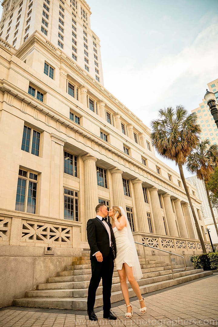 Couple sharing a tender moment at sunset during their intimate Miami elopement, with vibrant colors and ocean views in the background.