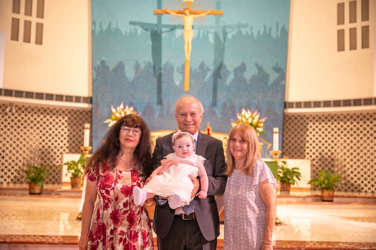 Priest performing baptism ritual at St. Rose of Lima Church in Miami