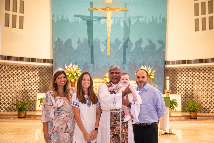 Candid baptism moment at St. Rose of Lima Church in Miami by professional photographer