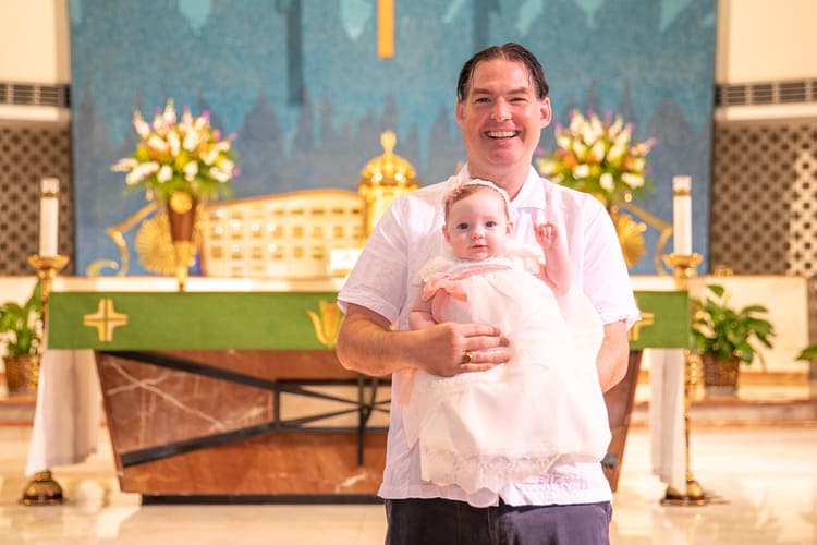 Close-up of baptism candle being lit inside St. Rose of Lima Church in Miami