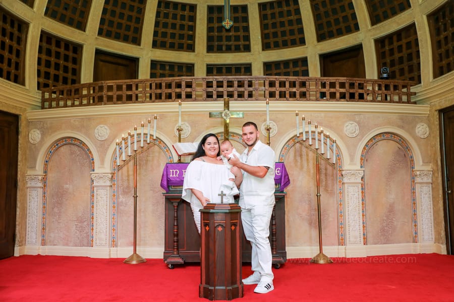 Baby wrapped in white blanket during baptism ceremony at Coral Gables United Church of Christ in Miami