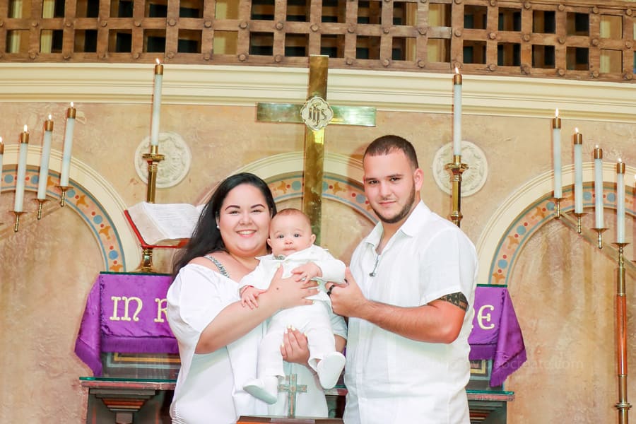 Priest blessing baby during baptism ceremony at Coral Gables United Church of Christ in Miami